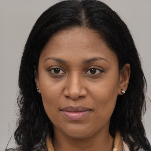 Joyful black young-adult female with long  brown hair and brown eyes