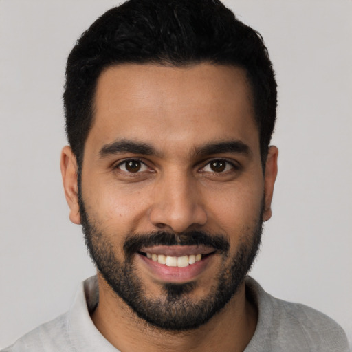 Joyful latino young-adult male with short  black hair and brown eyes