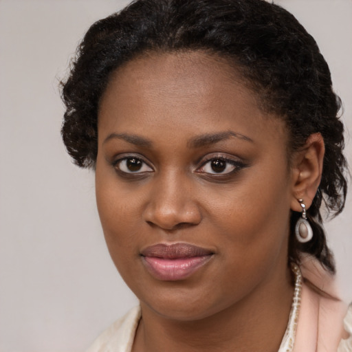 Joyful black young-adult female with long  brown hair and brown eyes