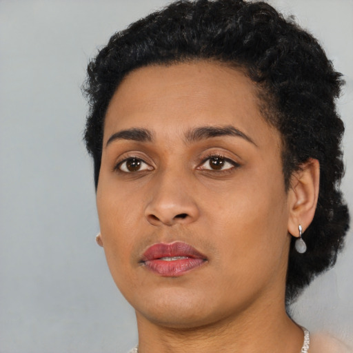 Joyful black young-adult female with short  black hair and brown eyes