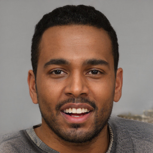 Joyful black young-adult male with short  black hair and brown eyes