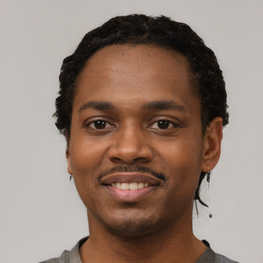 Joyful black young-adult male with short  black hair and brown eyes