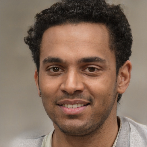 Joyful black young-adult male with short  black hair and brown eyes