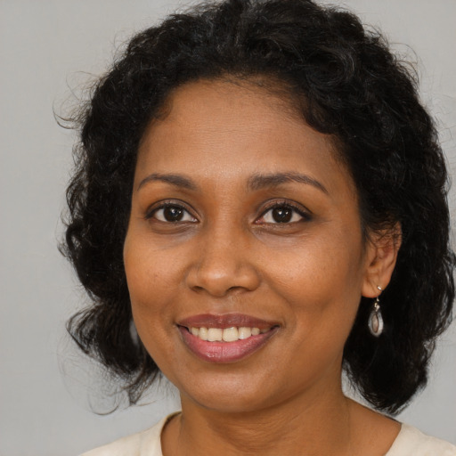 Joyful black young-adult female with medium  brown hair and brown eyes