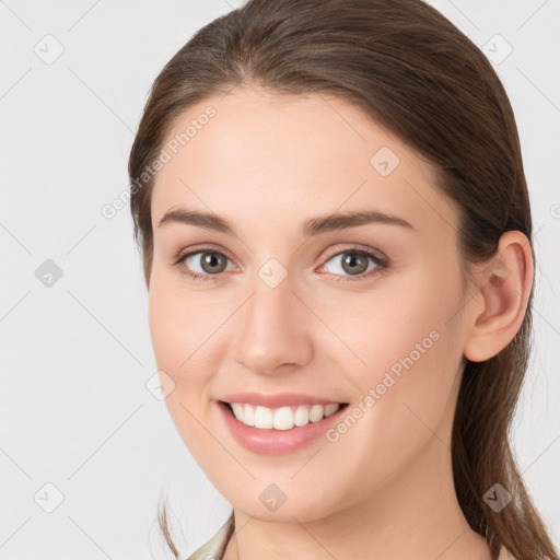 Joyful white young-adult female with long  brown hair and grey eyes