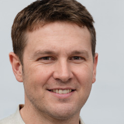 Joyful white adult male with short  brown hair and grey eyes