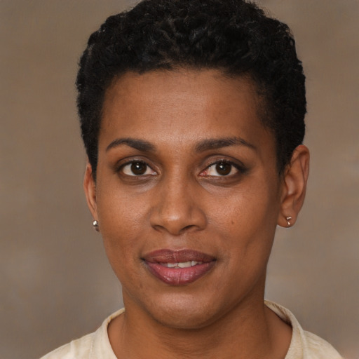 Joyful black young-adult female with short  black hair and brown eyes