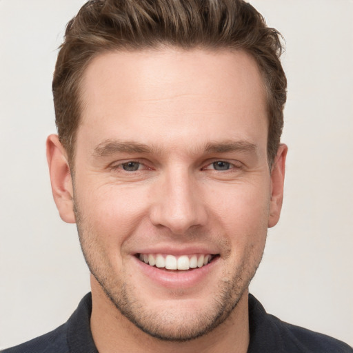 Joyful white young-adult male with short  brown hair and grey eyes