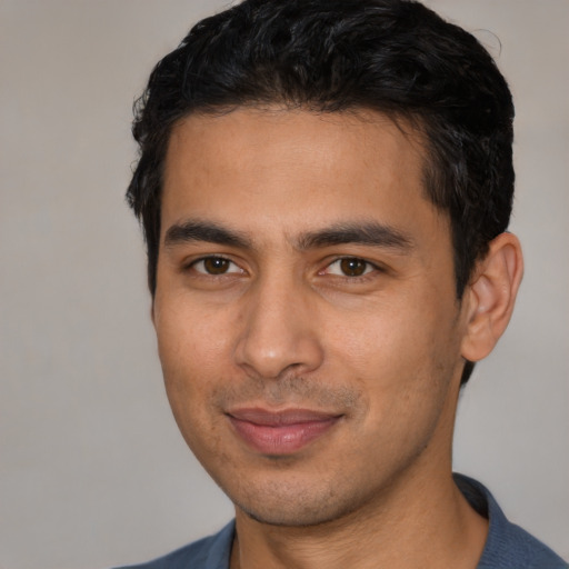 Joyful latino young-adult male with short  black hair and brown eyes