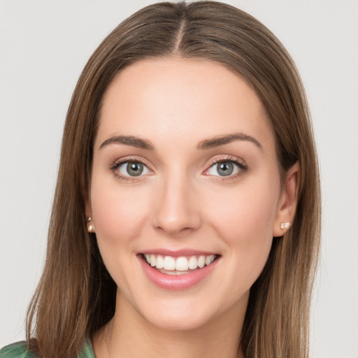 Joyful white young-adult female with long  brown hair and green eyes