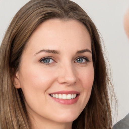 Joyful white young-adult female with long  brown hair and grey eyes