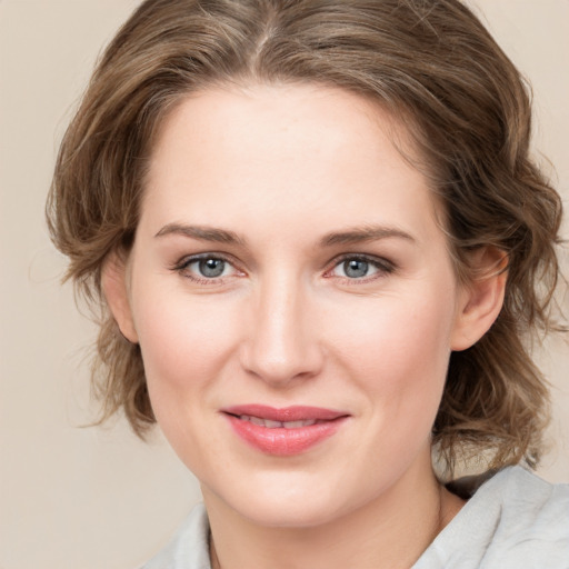 Joyful white young-adult female with medium  brown hair and green eyes