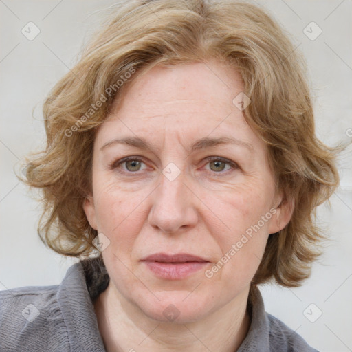 Joyful white adult female with medium  brown hair and blue eyes