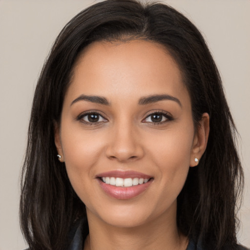 Joyful latino young-adult female with long  brown hair and brown eyes