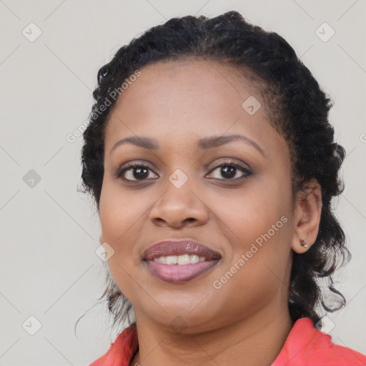 Joyful black young-adult female with long  brown hair and brown eyes