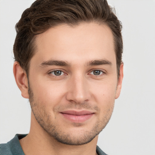 Joyful white young-adult male with short  brown hair and grey eyes