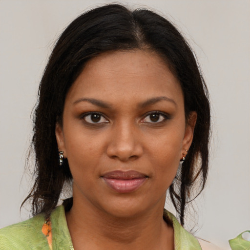 Joyful black young-adult female with medium  brown hair and brown eyes