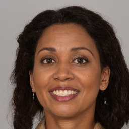 Joyful black adult female with long  brown hair and brown eyes