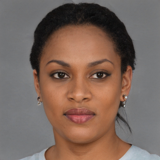 Joyful black young-adult female with short  black hair and brown eyes