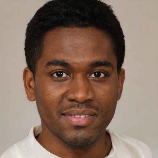 Joyful black young-adult male with short  brown hair and brown eyes