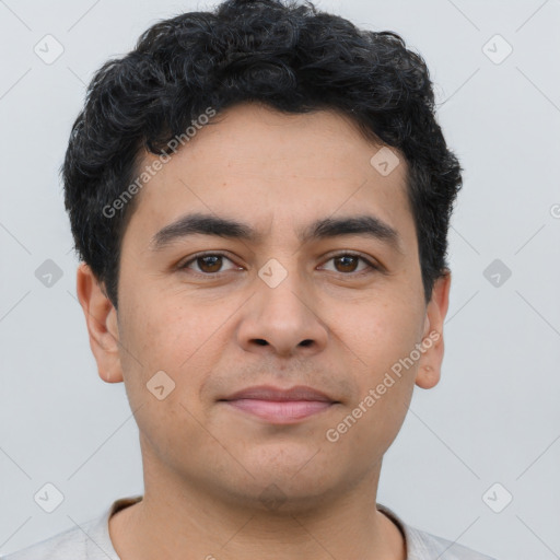 Joyful latino young-adult male with short  brown hair and brown eyes