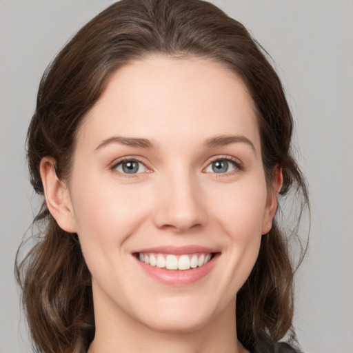 Joyful white young-adult female with medium  brown hair and grey eyes