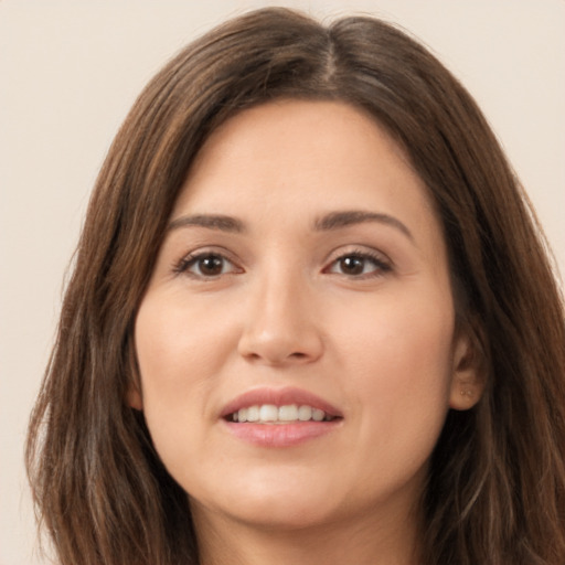 Joyful white young-adult female with long  brown hair and brown eyes