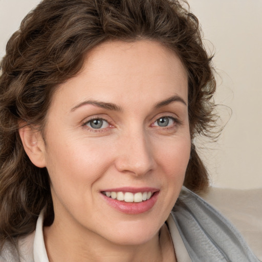 Joyful white young-adult female with medium  brown hair and blue eyes