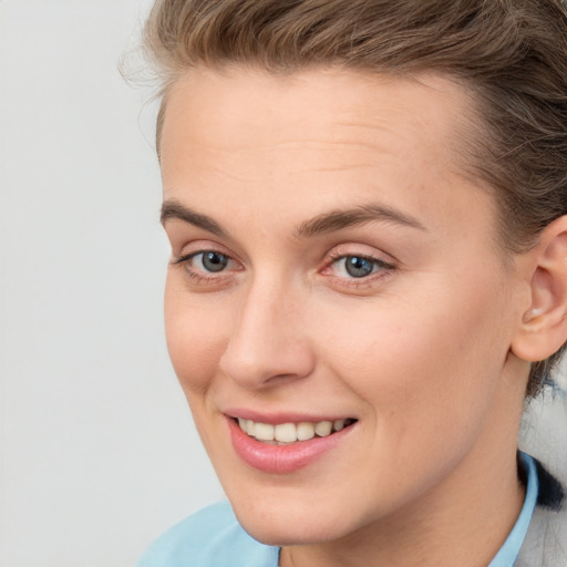 Joyful white young-adult female with short  brown hair and blue eyes