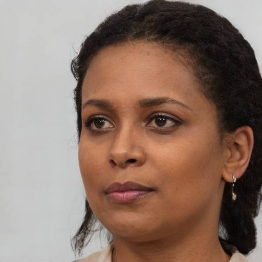 Neutral black young-adult female with medium  brown hair and brown eyes
