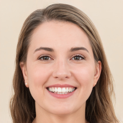 Joyful white young-adult female with long  brown hair and brown eyes