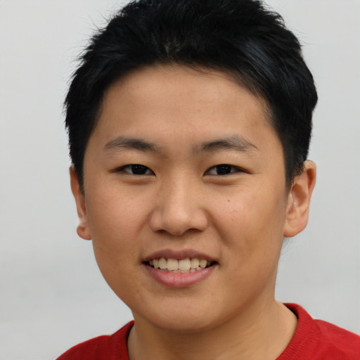 Joyful asian young-adult male with short  black hair and brown eyes