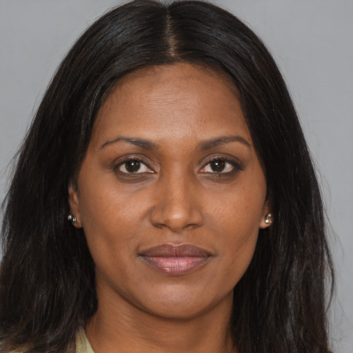 Joyful black young-adult female with long  brown hair and brown eyes