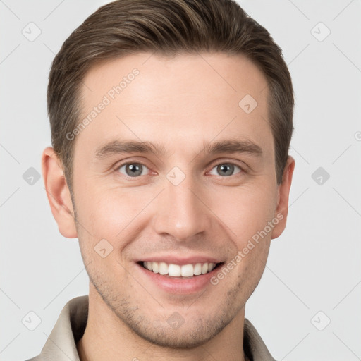 Joyful white young-adult male with short  brown hair and grey eyes