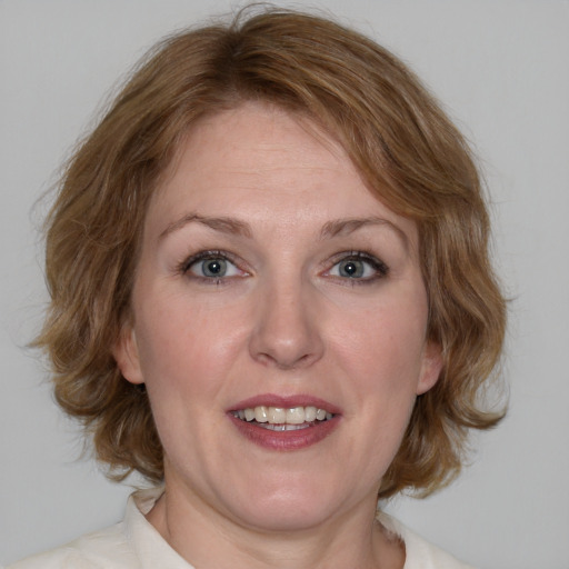 Joyful white adult female with medium  brown hair and blue eyes