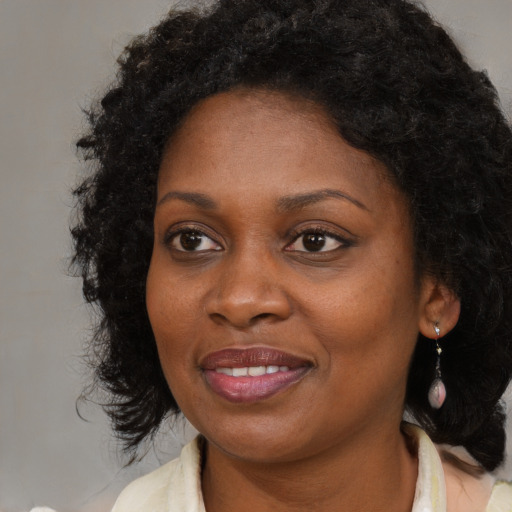 Joyful black adult female with medium  brown hair and brown eyes