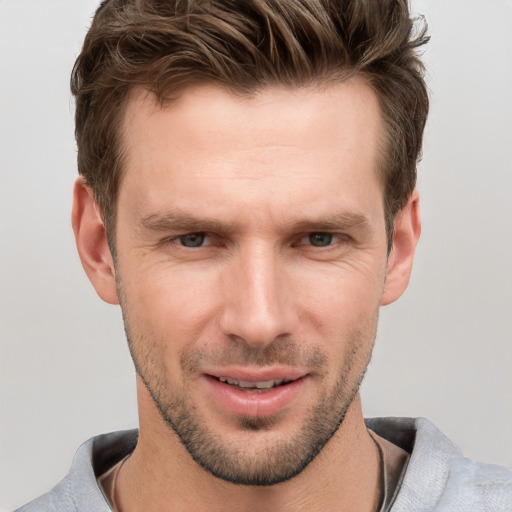 Joyful white adult male with short  brown hair and grey eyes