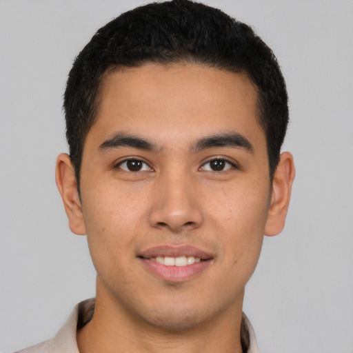 Joyful latino young-adult male with short  brown hair and brown eyes