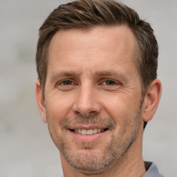 Joyful white adult male with short  brown hair and grey eyes