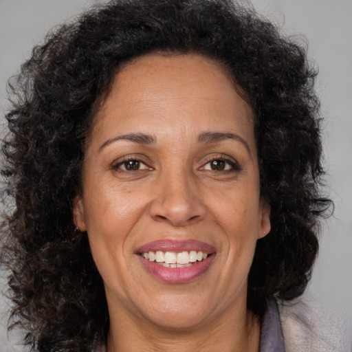 Joyful black adult female with medium  brown hair and brown eyes