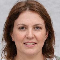 Joyful white adult female with medium  brown hair and grey eyes