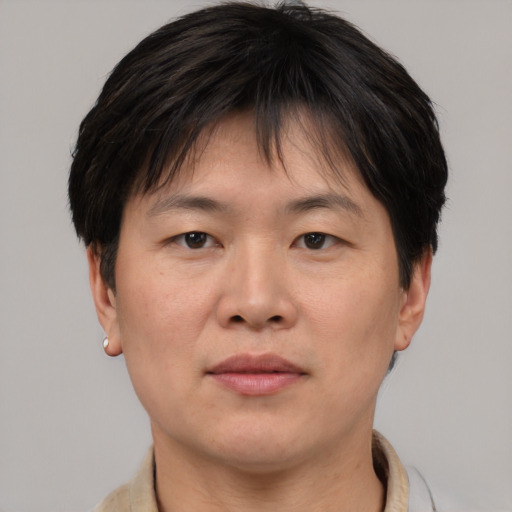 Joyful asian adult male with short  brown hair and brown eyes