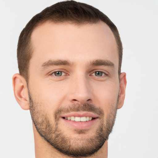 Joyful white young-adult male with short  brown hair and grey eyes