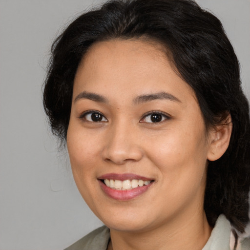 Joyful latino young-adult female with medium  brown hair and brown eyes