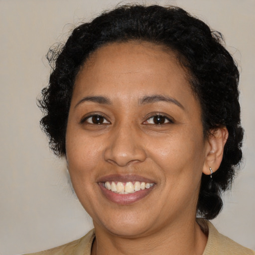 Joyful latino adult female with medium  brown hair and brown eyes