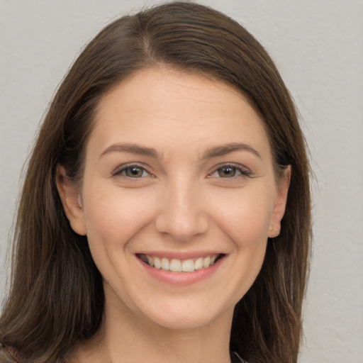 Joyful white young-adult female with long  brown hair and brown eyes