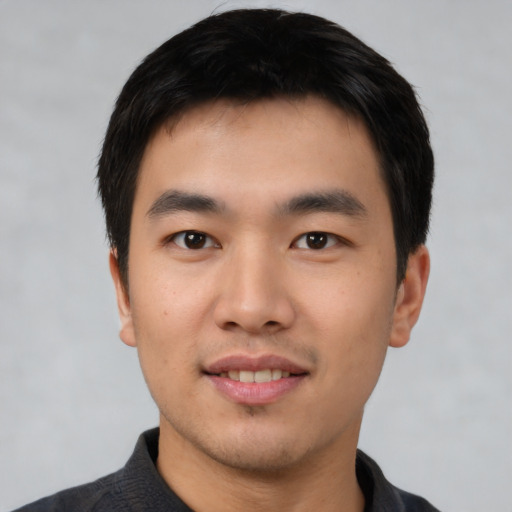 Joyful asian young-adult male with short  black hair and brown eyes