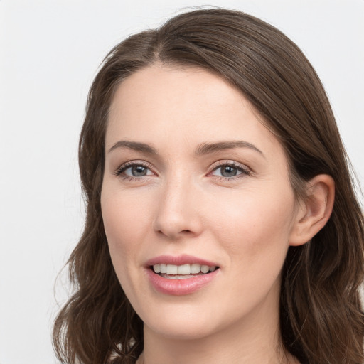 Joyful white young-adult female with long  brown hair and grey eyes