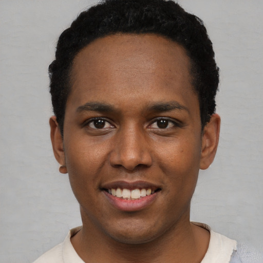 Joyful black young-adult male with short  black hair and brown eyes