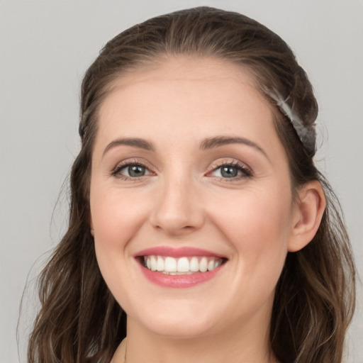 Joyful white young-adult female with long  brown hair and grey eyes